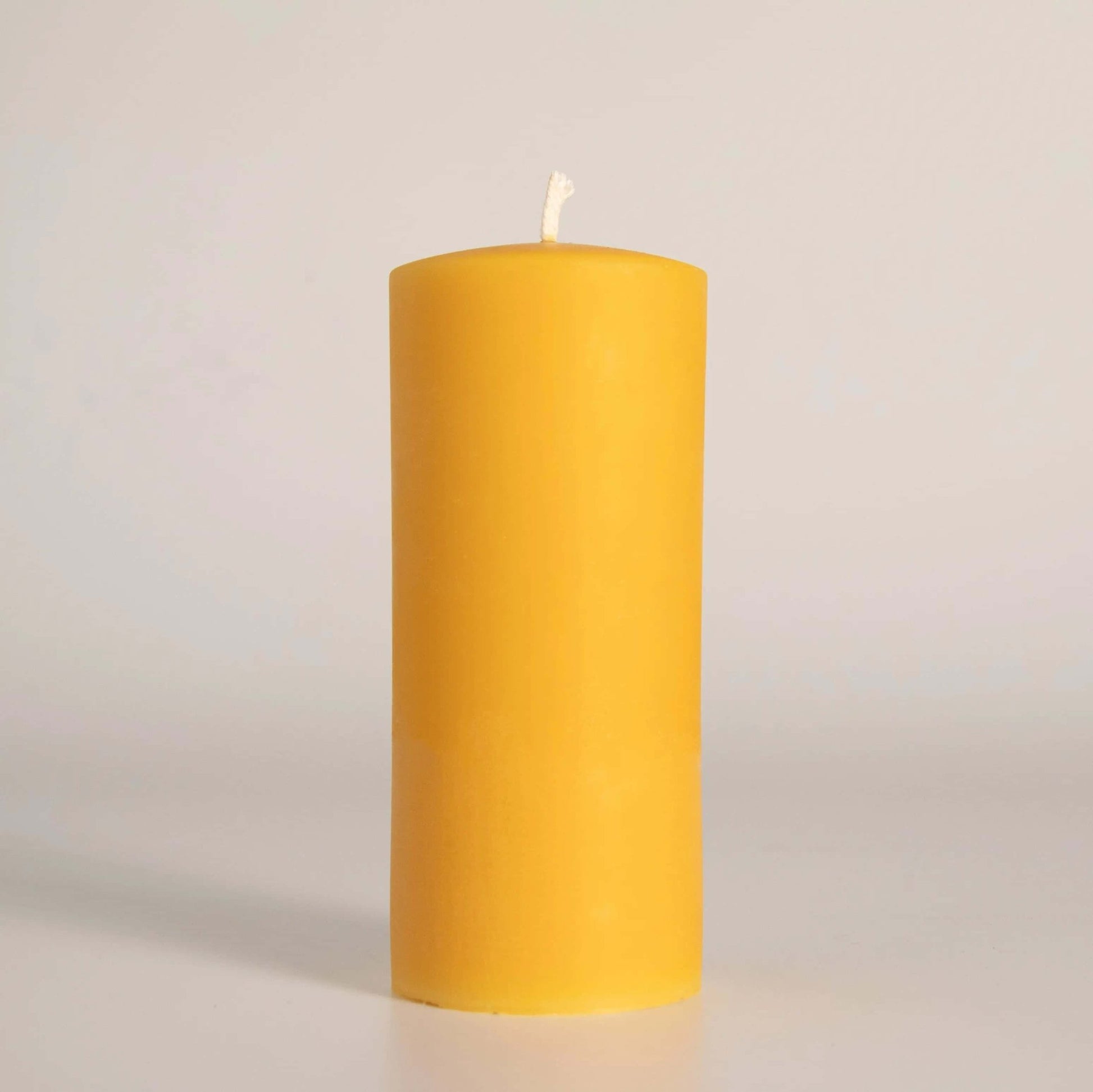 Bougie pilier en cire d'abeille jaune, fabriquée artisanalement à la main en Gaspésie, Québec. Éclairage naturel et durable pour votre maison.