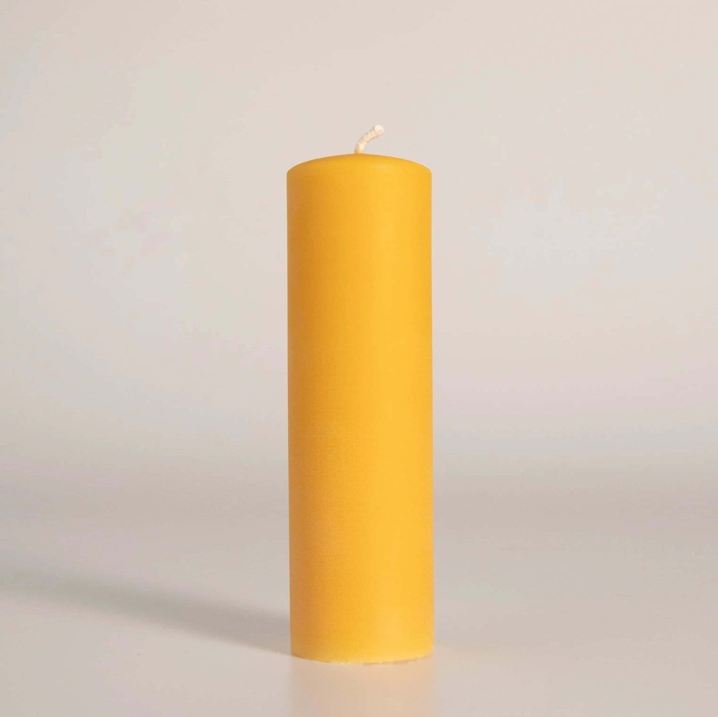 Bougie pilier en cire d'abeille jaune, fabriquée artisanalement à la main en Gaspésie, Québec. Éclairage naturel et durable pour votre maison.