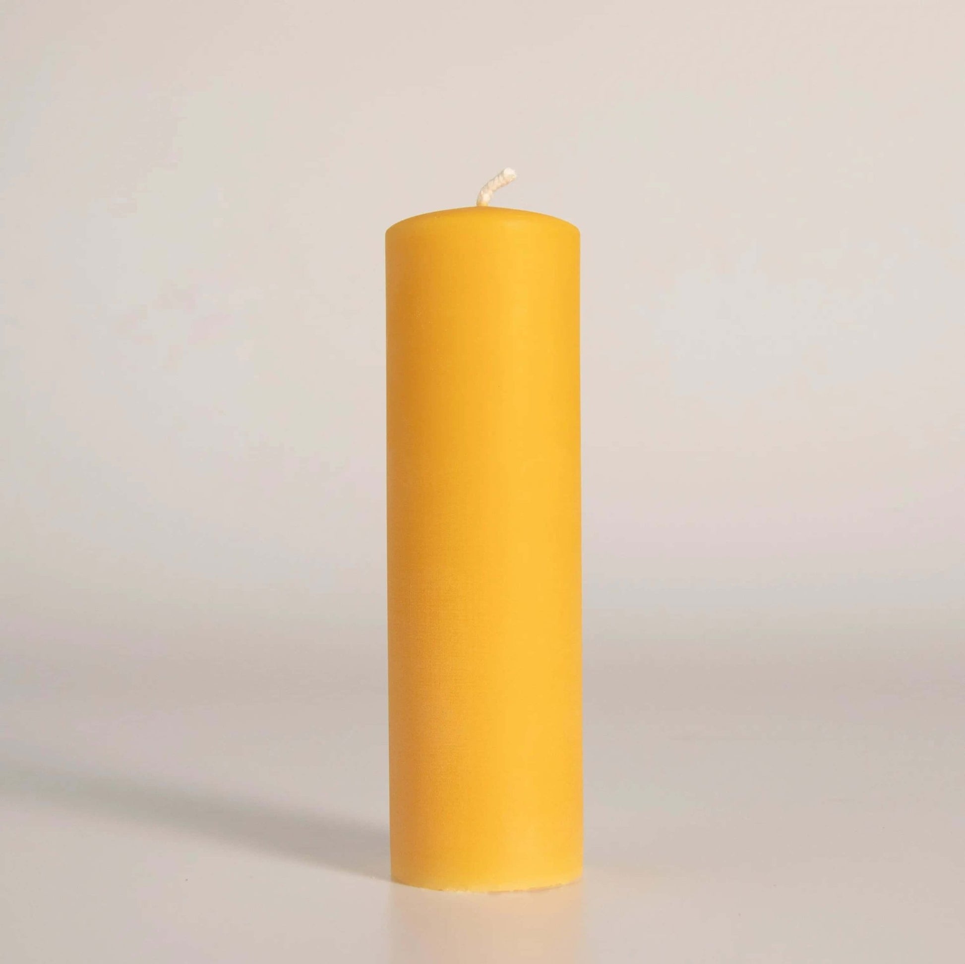 Bougie pilier en cire d'abeille jaune, fabriquée artisanalement à la main en Gaspésie, Québec. Éclairage naturel et durable pour votre maison.